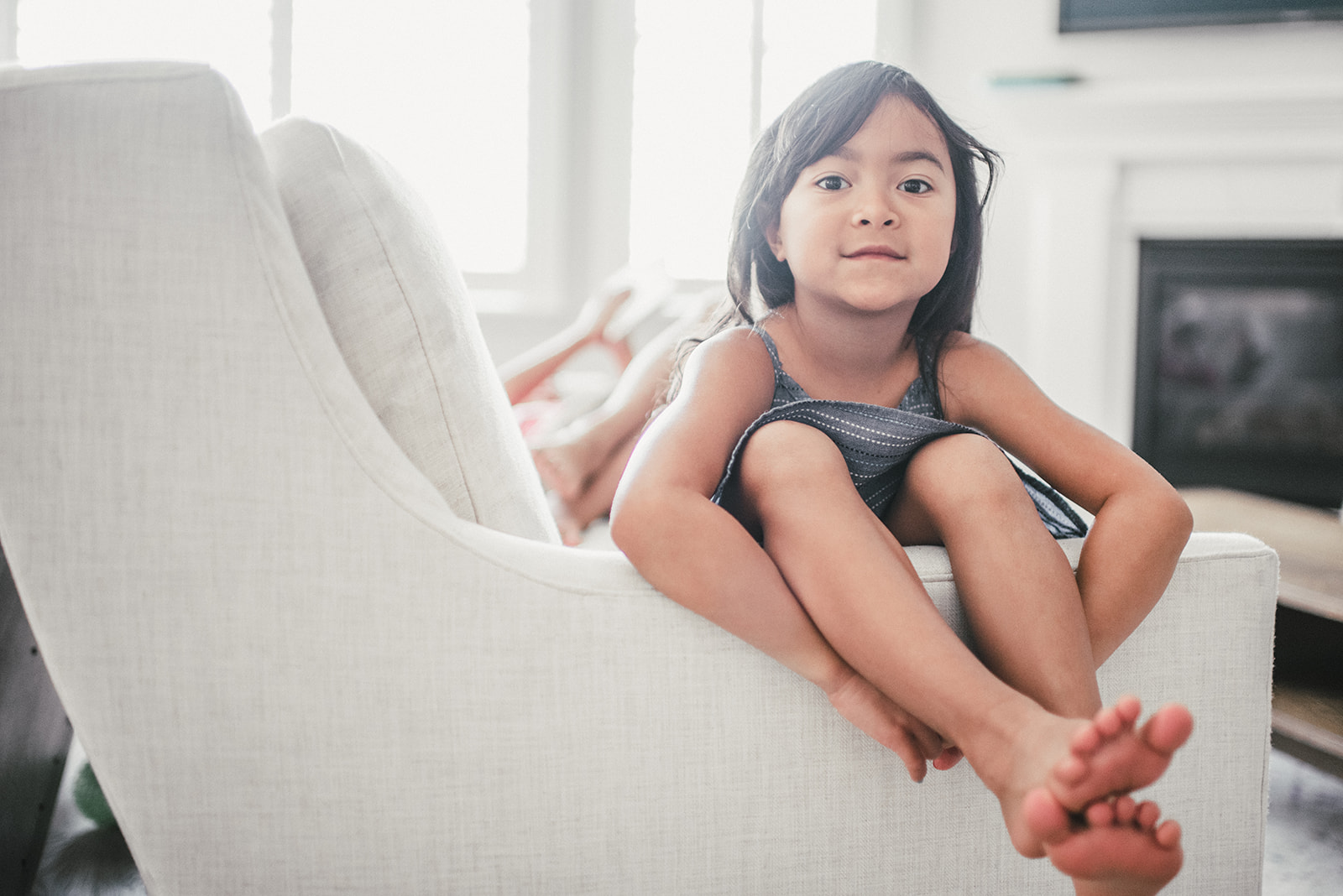 little girl sitting in white couch
