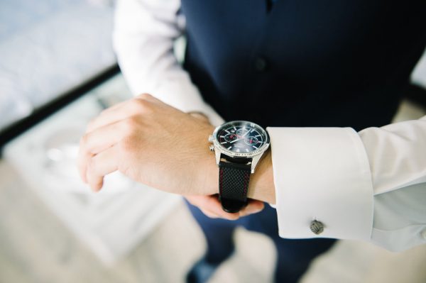 le marié vérifie sa montre pendant les préparatifs