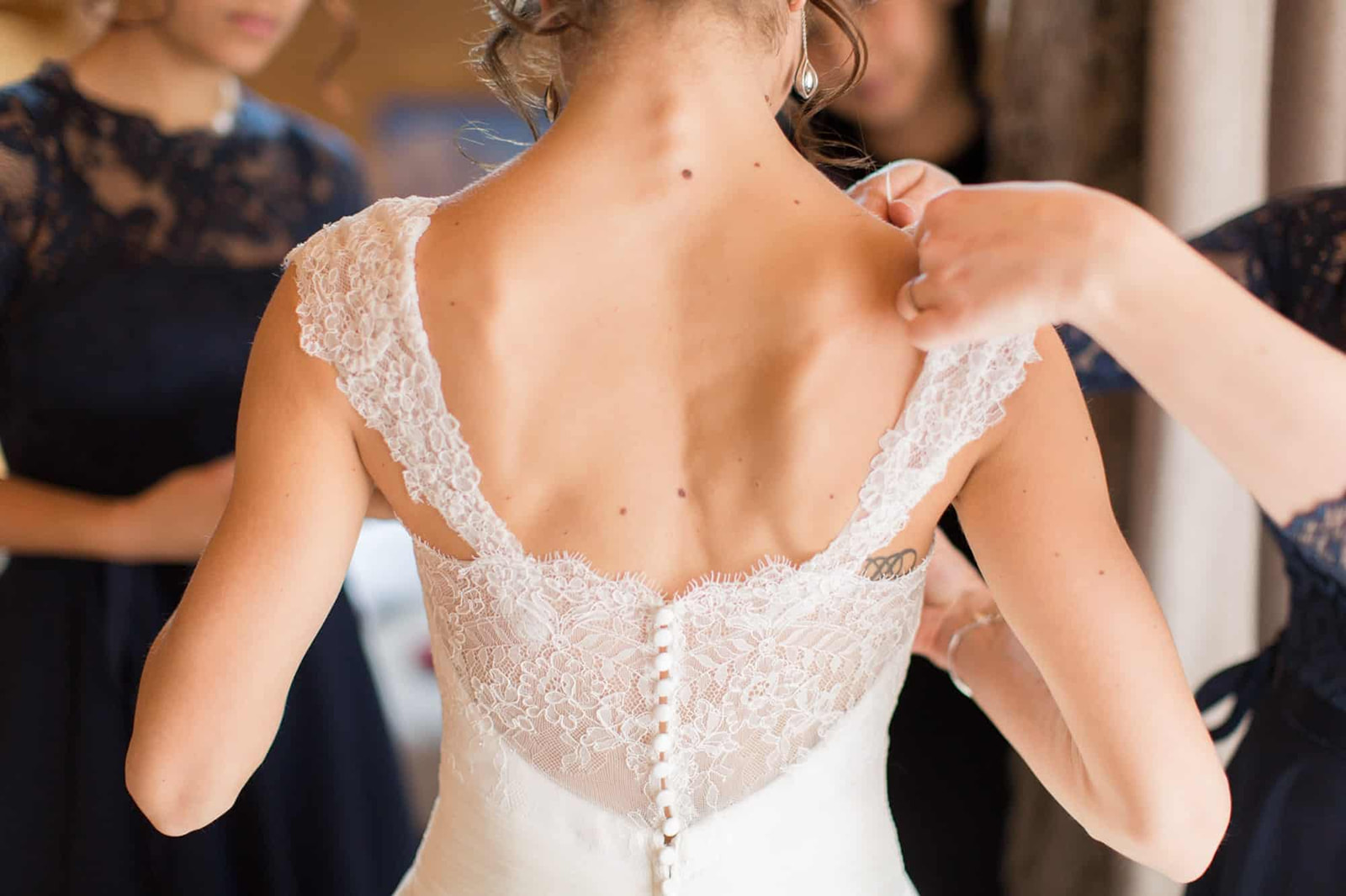 les demoiselles d'honneur ajuste la robe de la mariée