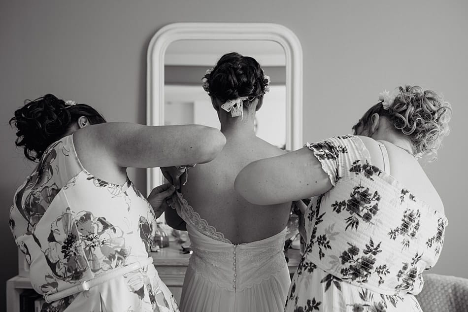 les demoiselles d'honneur aident la mariée