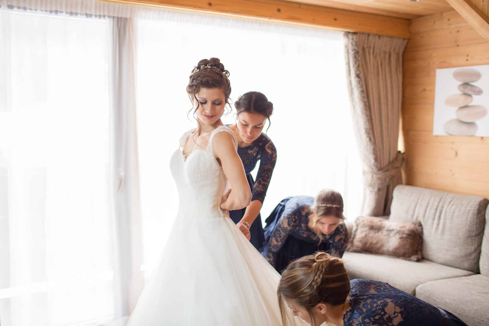 les demoiselles d'honneur aident à boutonner la robe