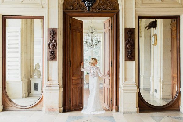 la marié pose dans l'ouverture de la porte du chateau