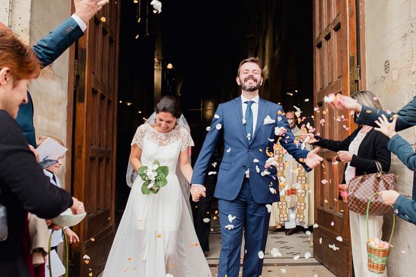 les mariés sortent de l'église sous une pluie de confettis