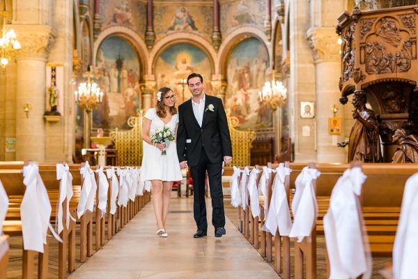les mariés marche dans l'allée principale de l'église