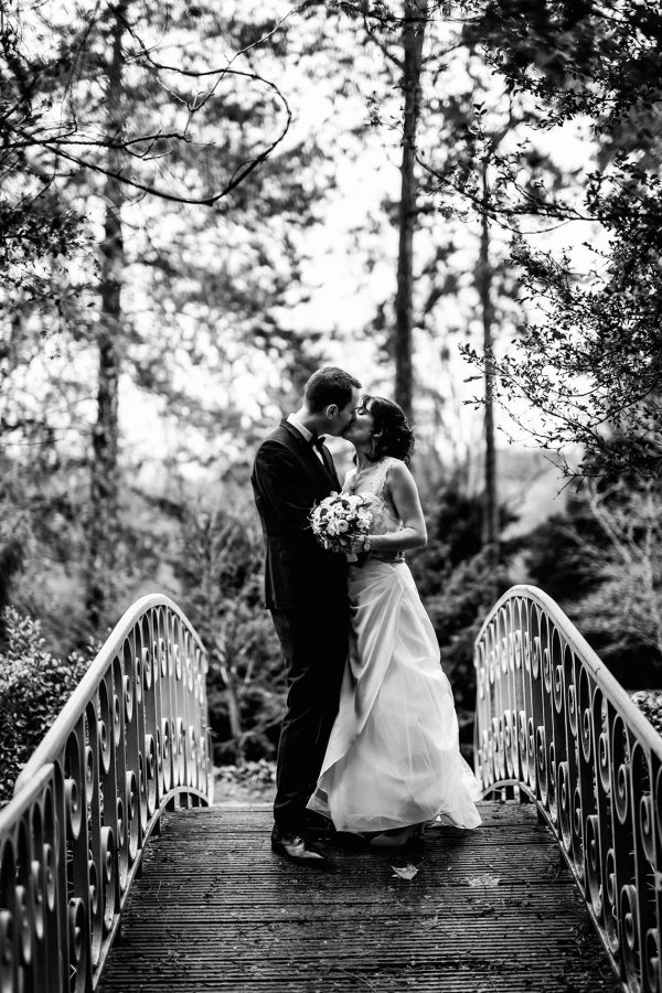 les mariés s'embrassent sur un pont