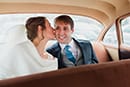 La mariée embrasse son mari dans la voiture