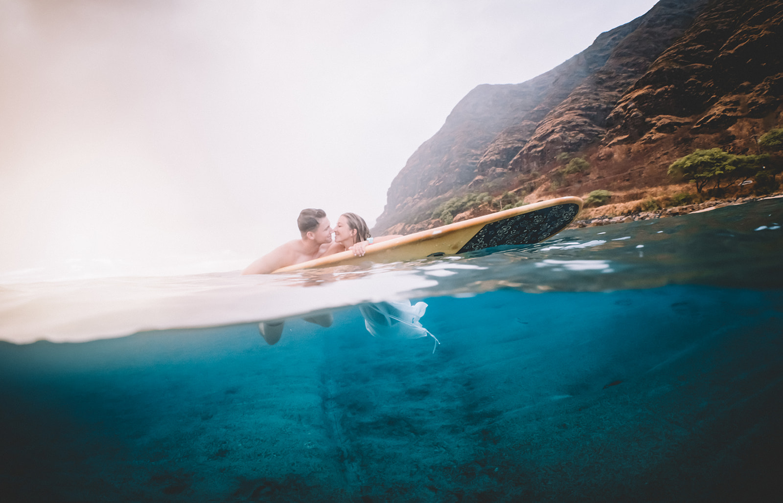 Underwater Couples Engagement Surfboard photos at Makua Beach on Oahu, Hawaii