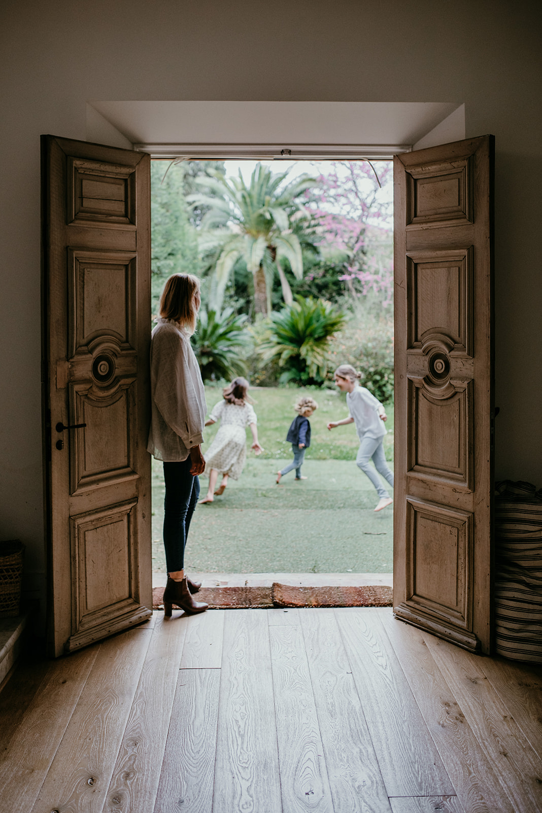 maman qui regardent ses enfants jouer dehors, par la porte