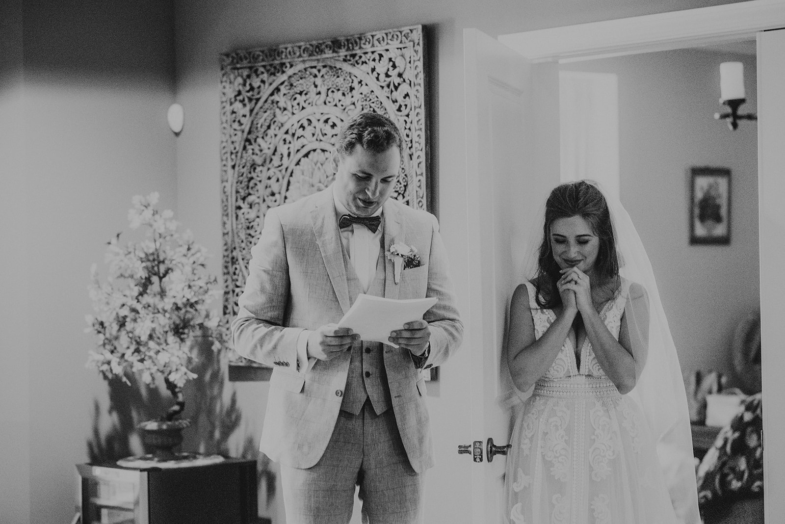 groom reading vows to bride from behind a door