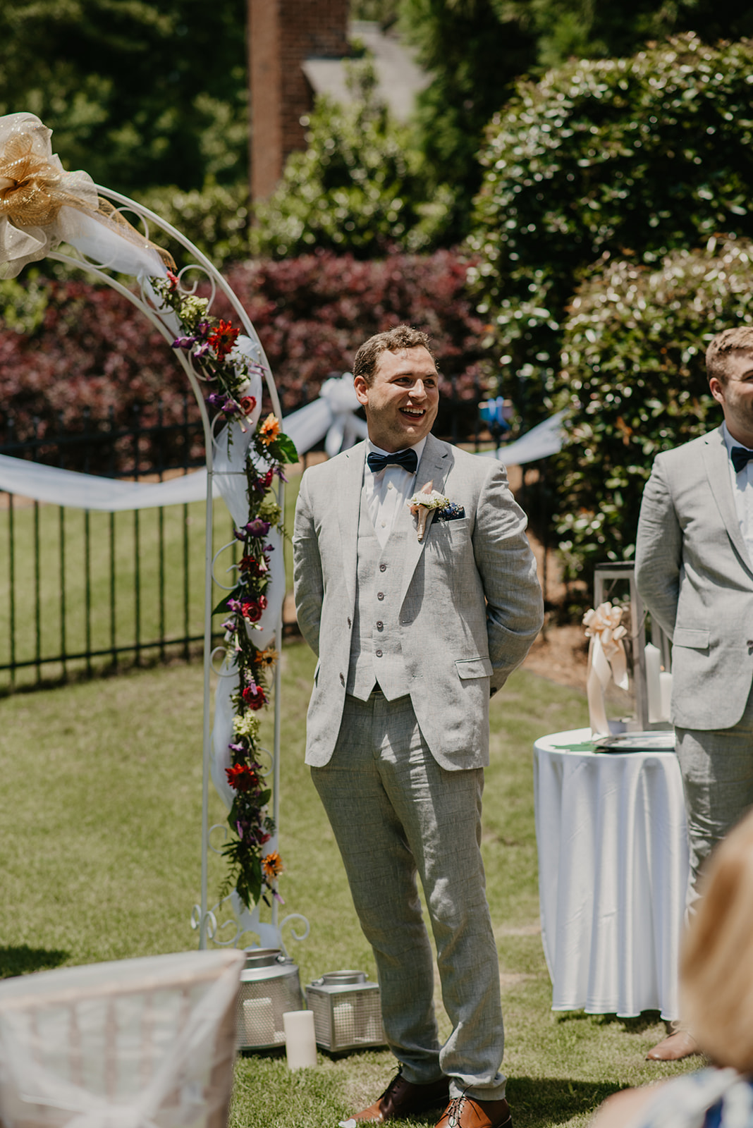 groom standing at outdoor altar waiting for bride to walk down aisle