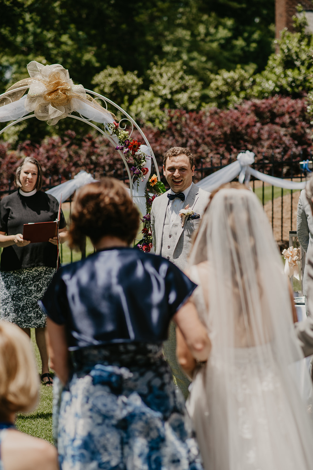 bride walking down aisle and groom smiling at her