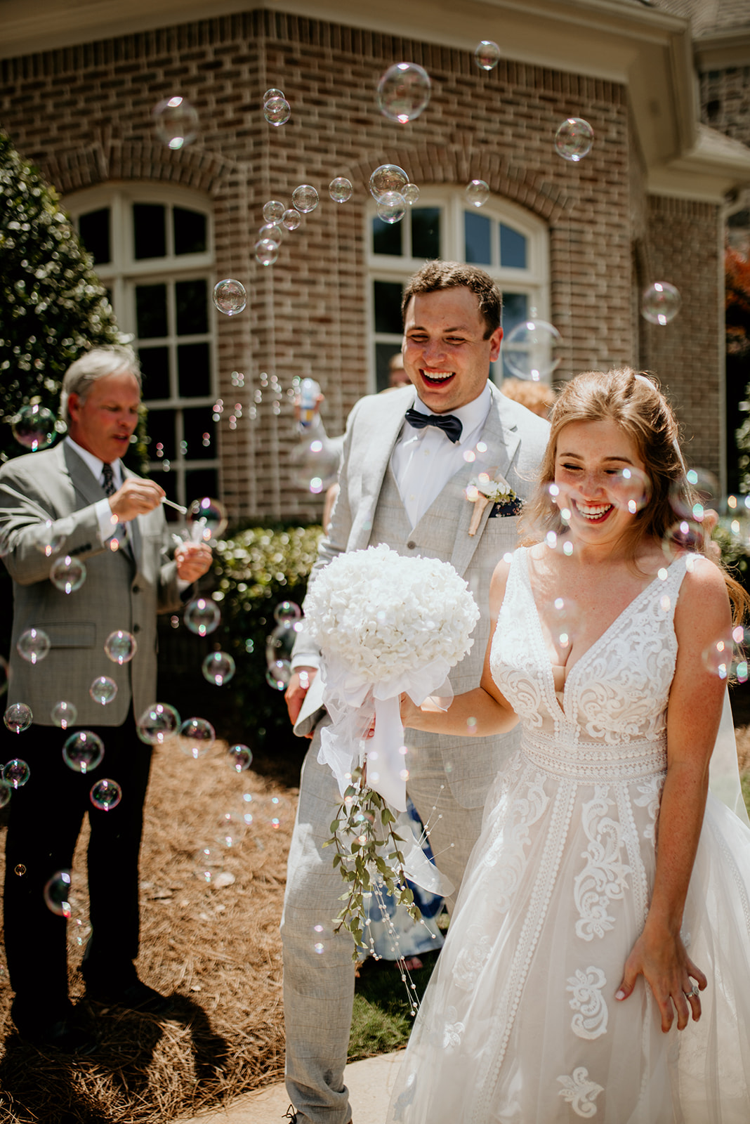bride and groom exiting while guests blow bubbles