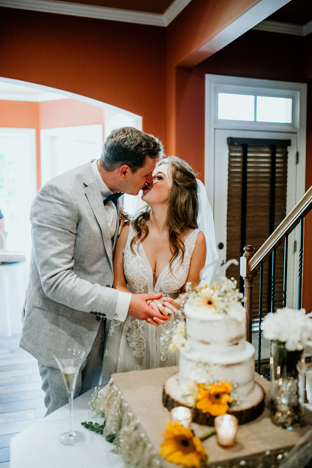 bride and groom kissing while cutting cake