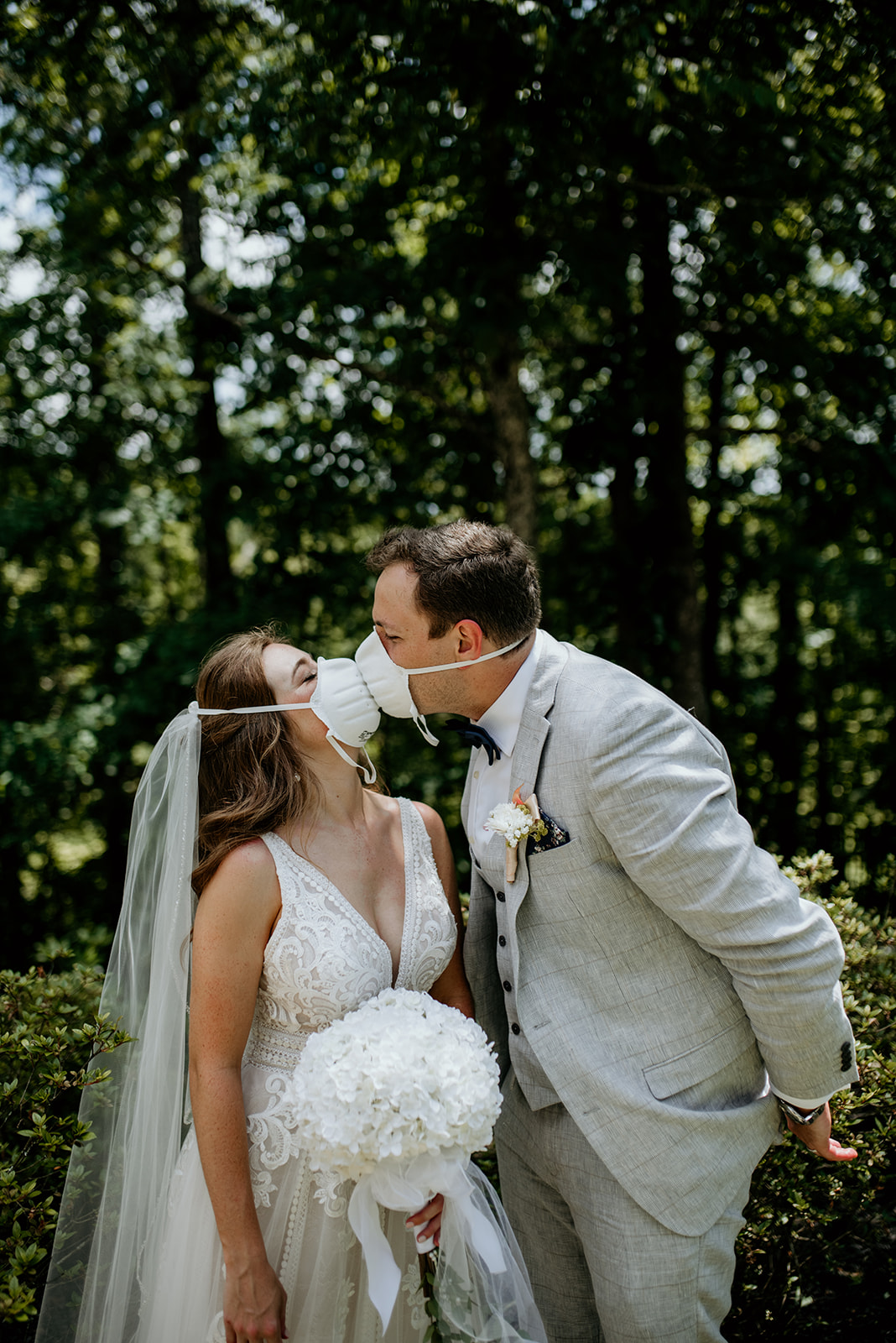 bride and groom kissing with n95 masks on