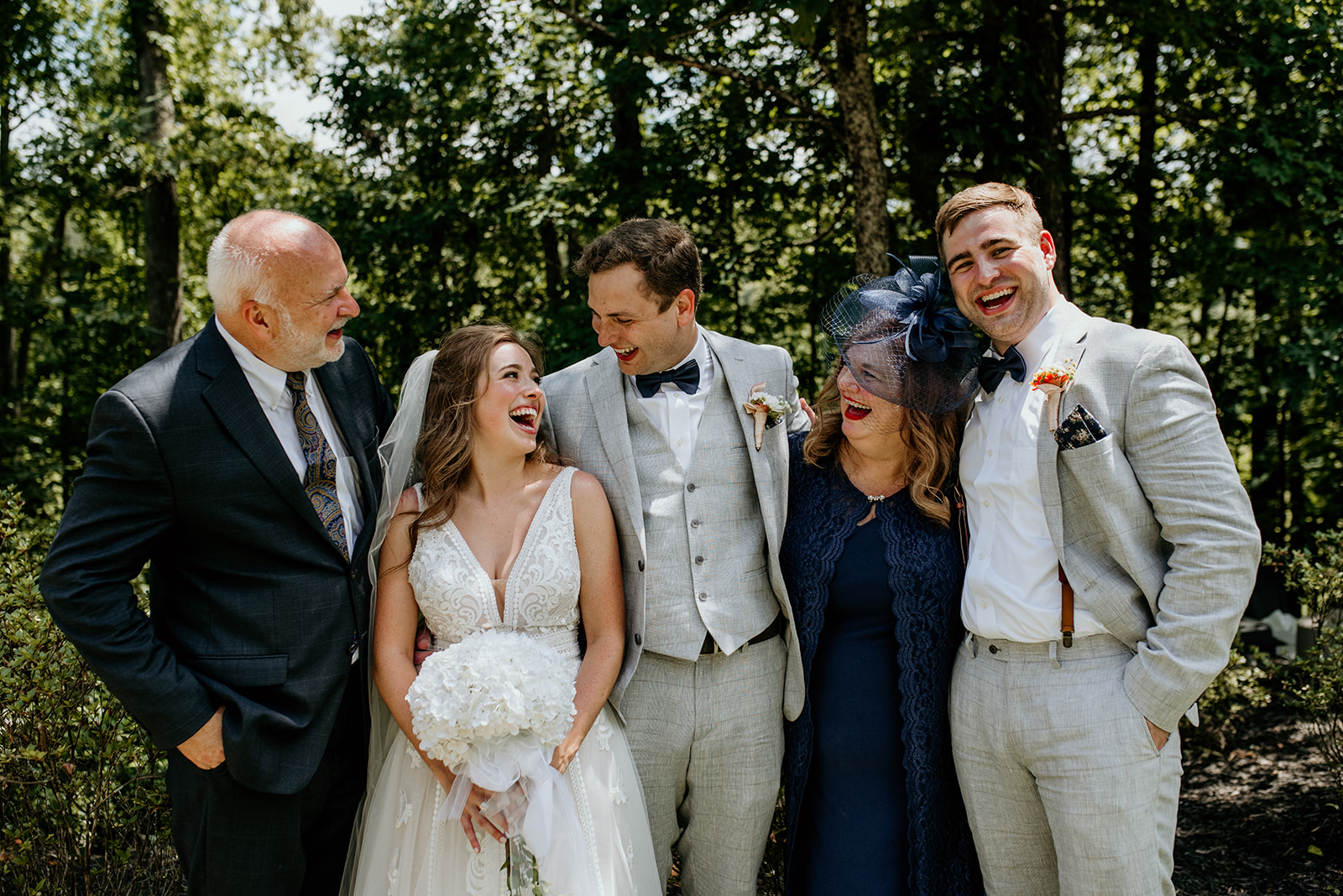 bride and groom with grooms parents and brother, all laughing