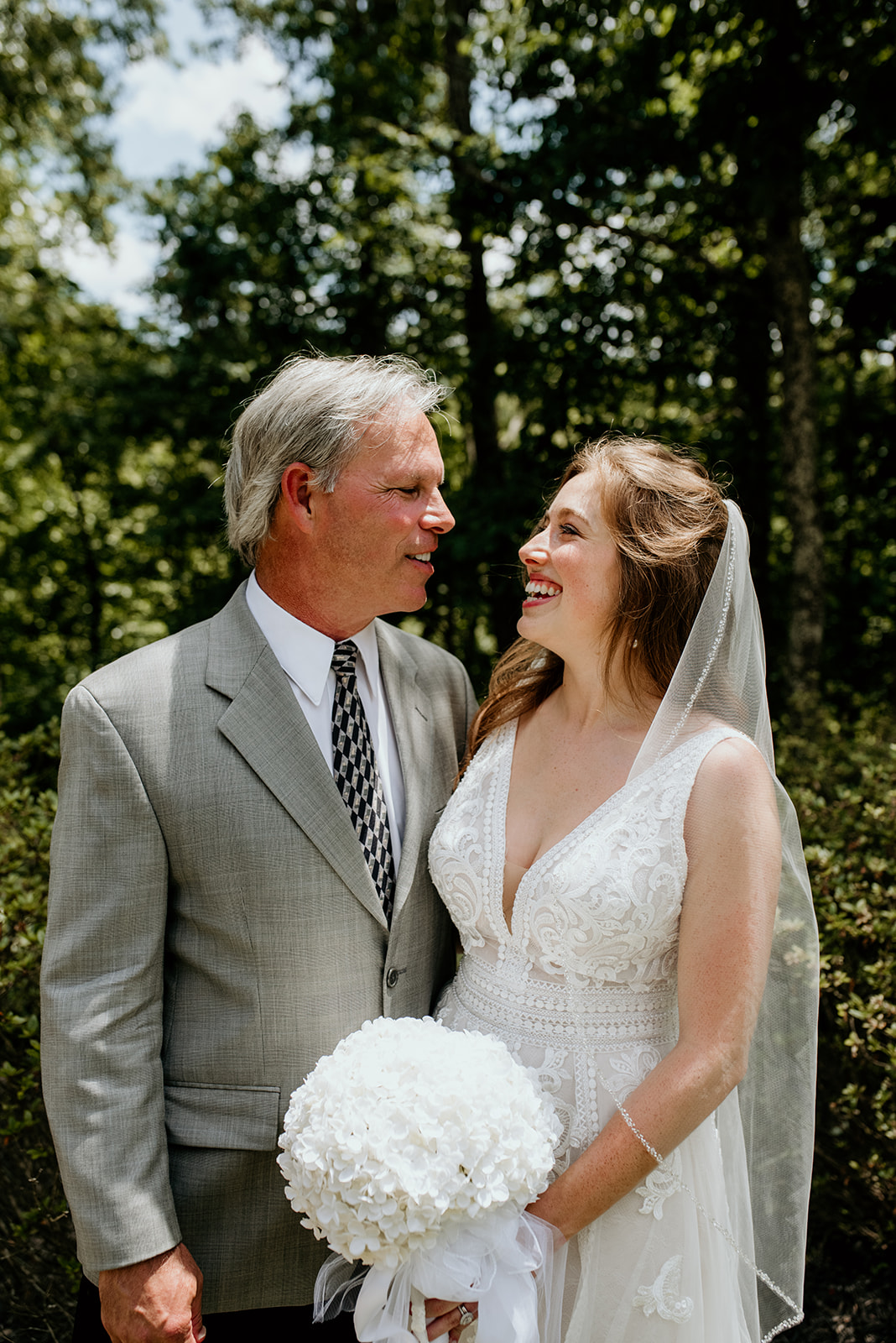 bride with father looking at each other smiling