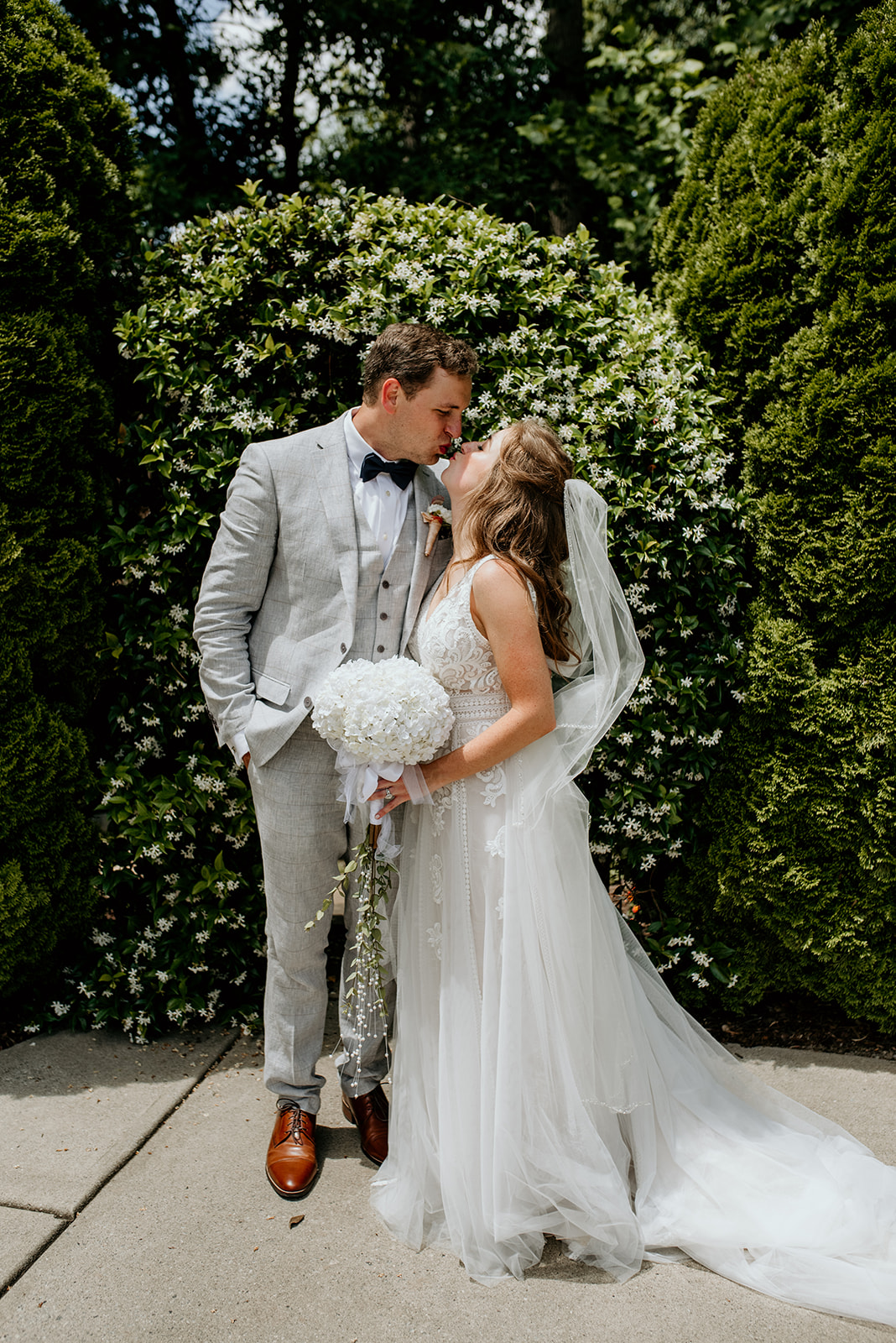 bride and groom kissing in front of an ivy archway