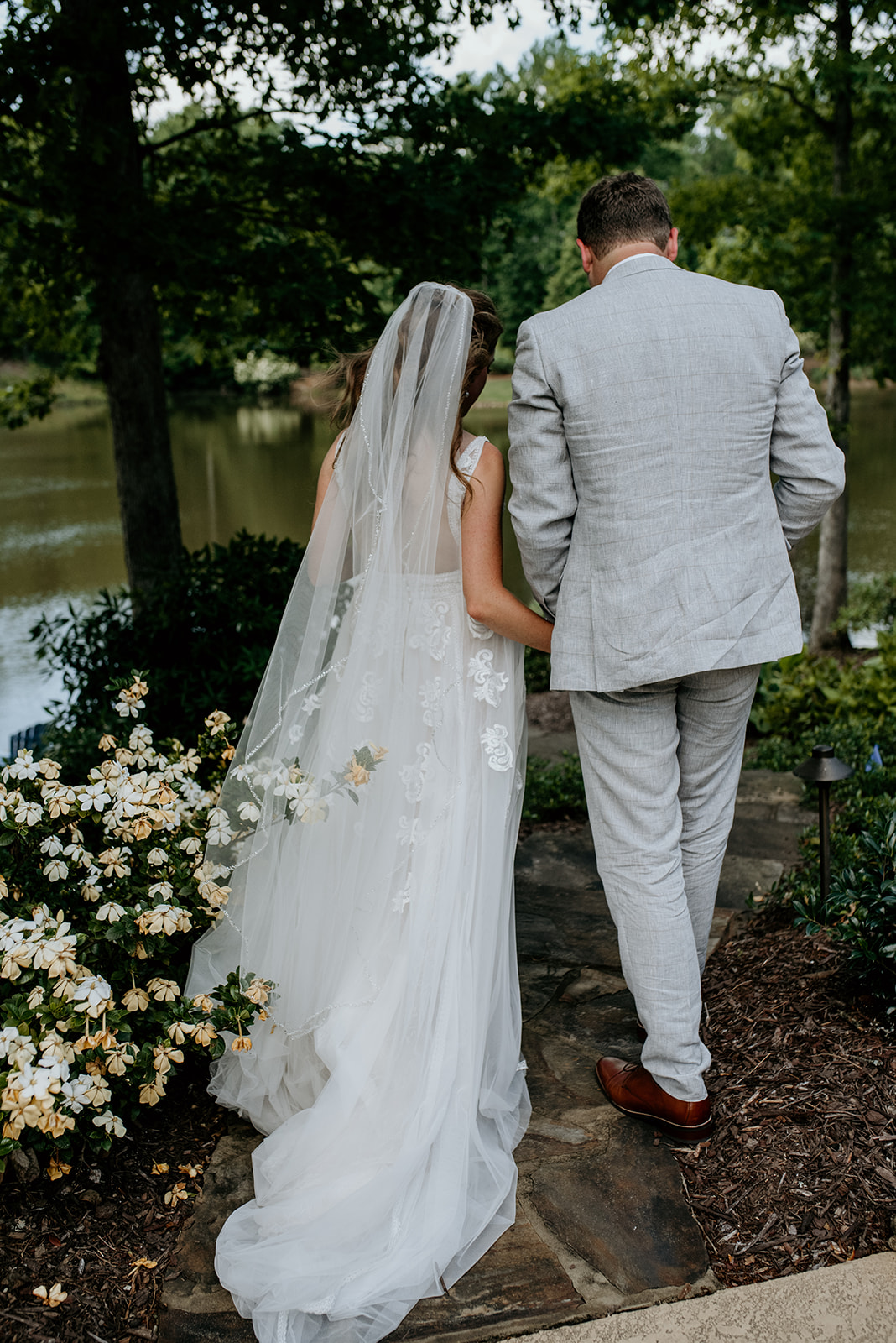 bride and groom walking down a path