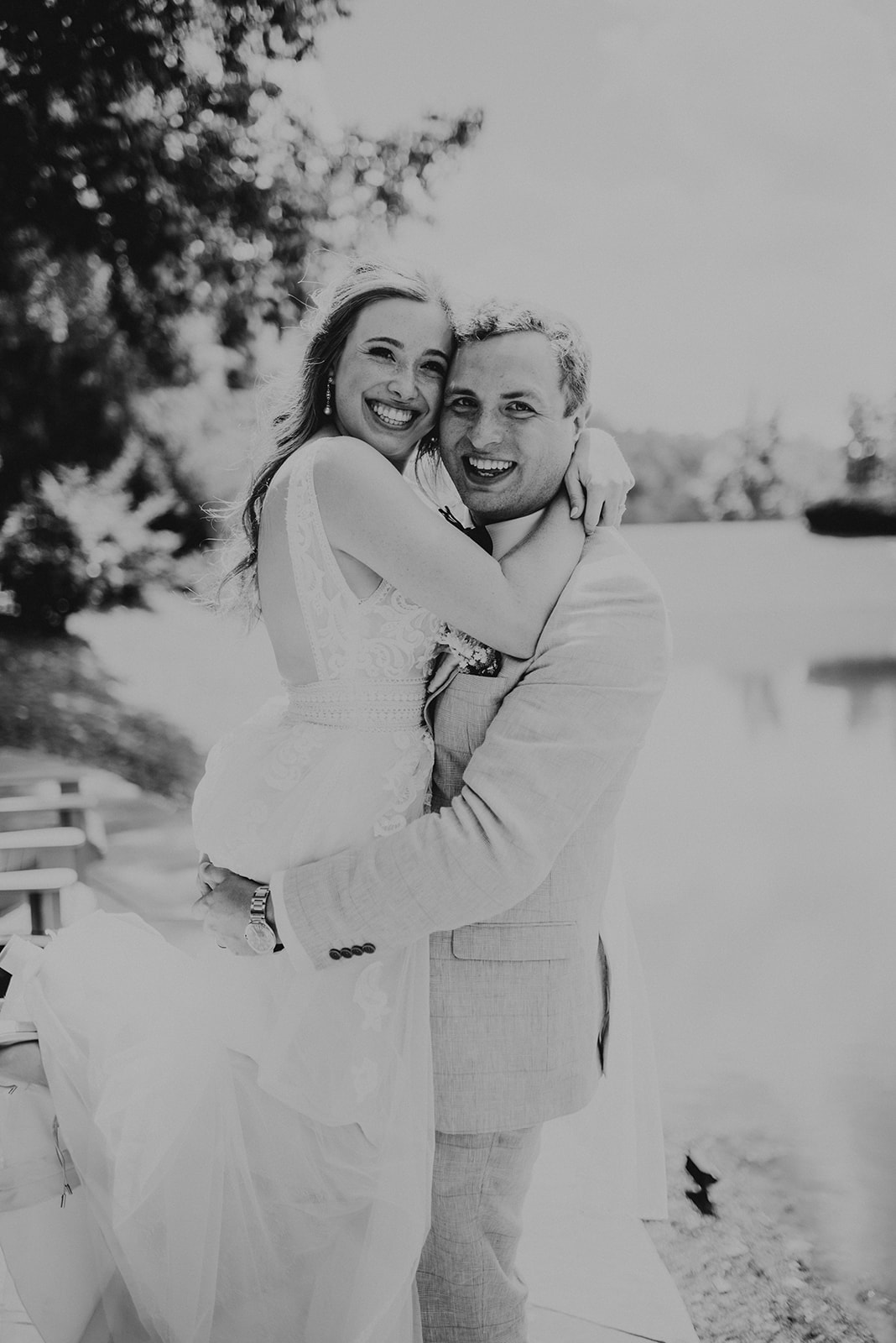 black and white of groom lifting bride with faces together smiling
