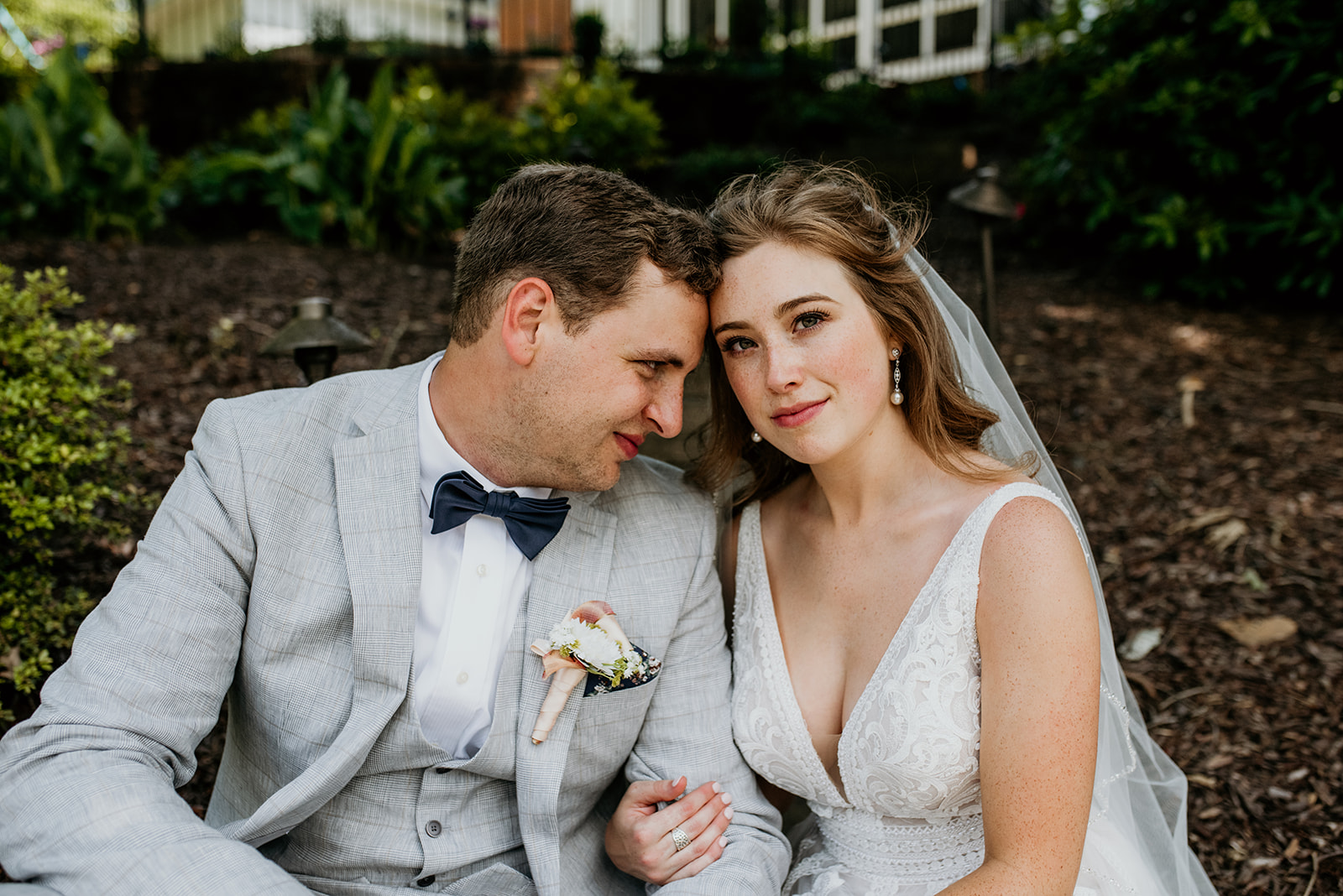 bride looking forward while groom looks at her