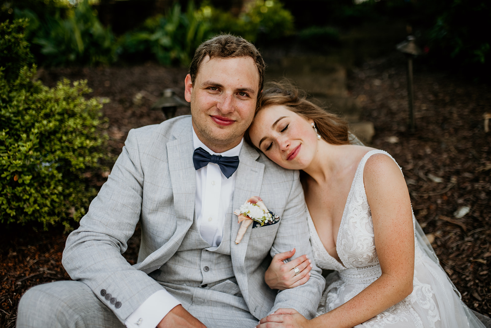 groom looking forward with bride resting her head on his shoulder with eyes closed