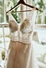 boho style wedding dress hanging in front of window