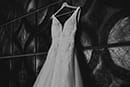 black and white of wedding dress hanging on tile wall