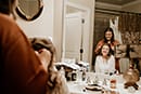 maid of honor doing brides hair in front of mirror