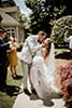 bride and groom kissing while guests blow bubbles around