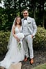 bride in boho style wedding dress and groom in grey tux with bowtie