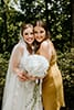 bride with maid of honor smiling with faces close together