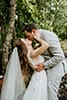 bride and groom kissing while bride holds grooms face