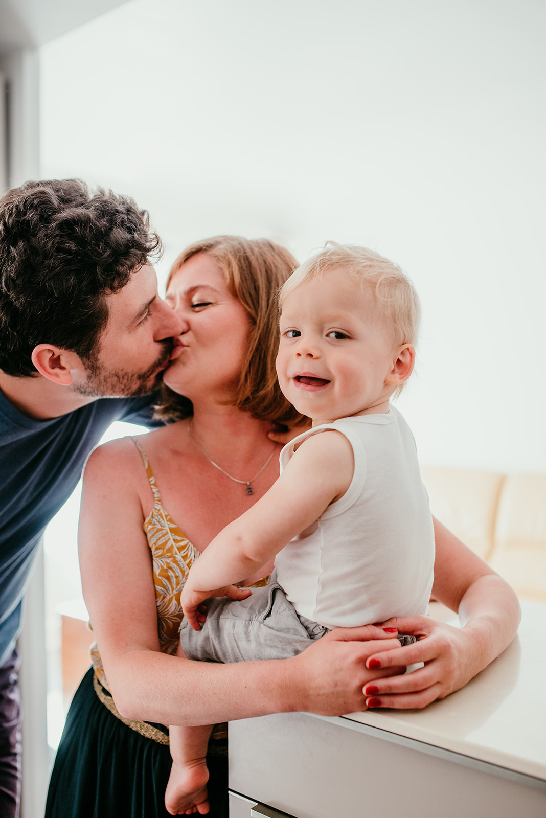 photos de famille couple qui s'embrasse, le bebe regarde
