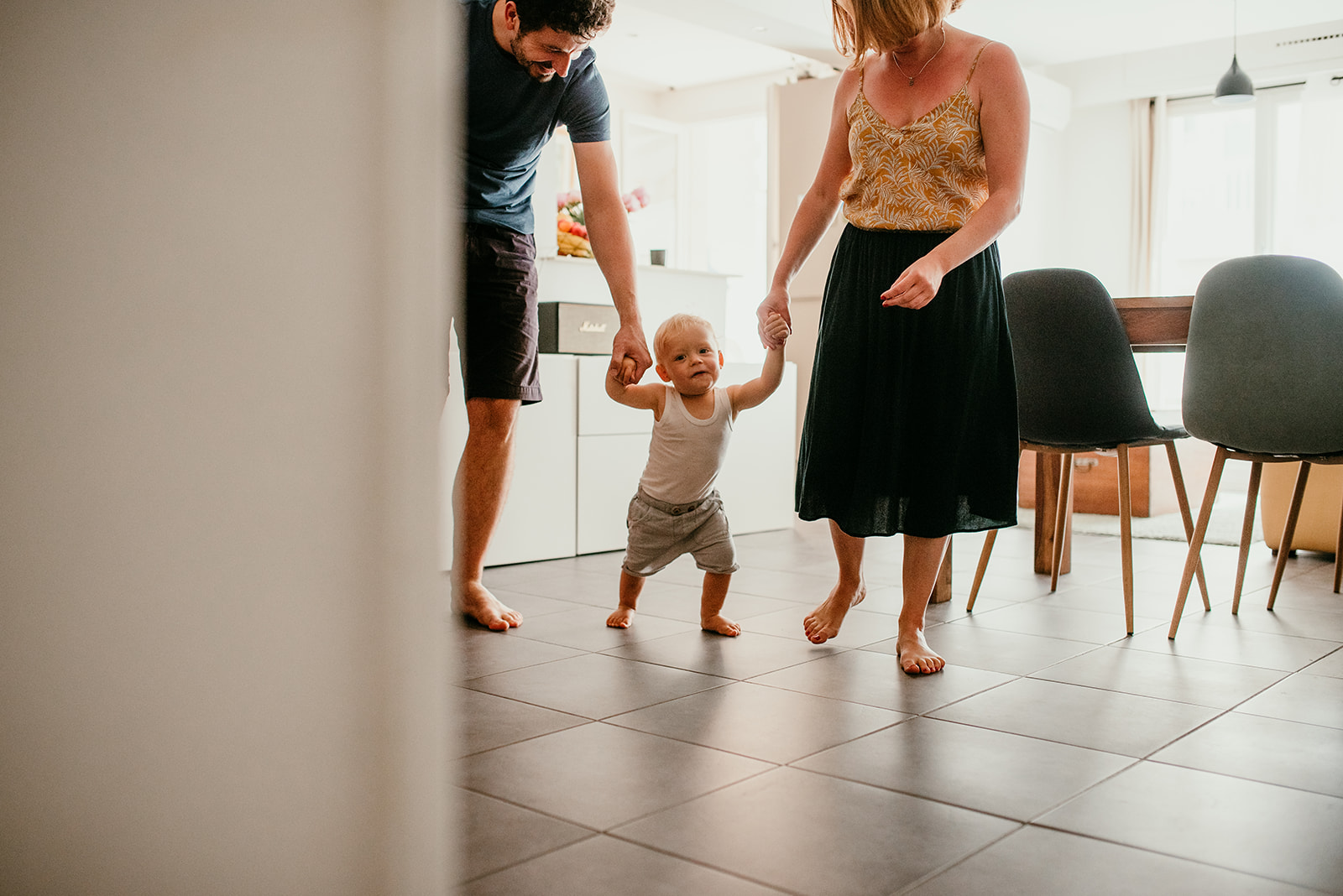 petit garcon marche aidé par ses parents