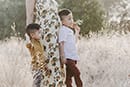 mom holding flower with two boys