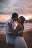 bride and groom kissing on Hawaiian white sand beach at sunset