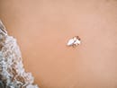 bride and groom looking up at the sky laying in sand aerial drone shot