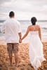 newlywed couple walking on Hawaiian beach