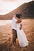 bride and groom embracing after Hawaii adventure elopement on white sand beach