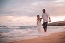 husband and wife walking in water on Hawaii shore