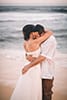 bride and groom soaking wet embracing at Hawaii beach