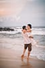husband holding wife smiling on Hawaii beach