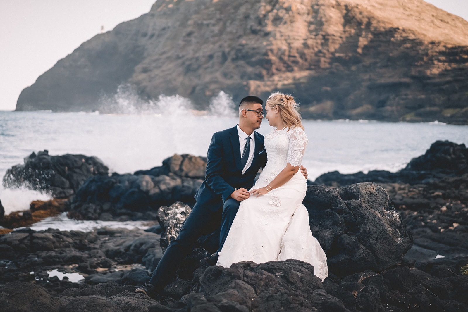 engaged couple forehead to forehead holding hands wave splashing makapuu beach