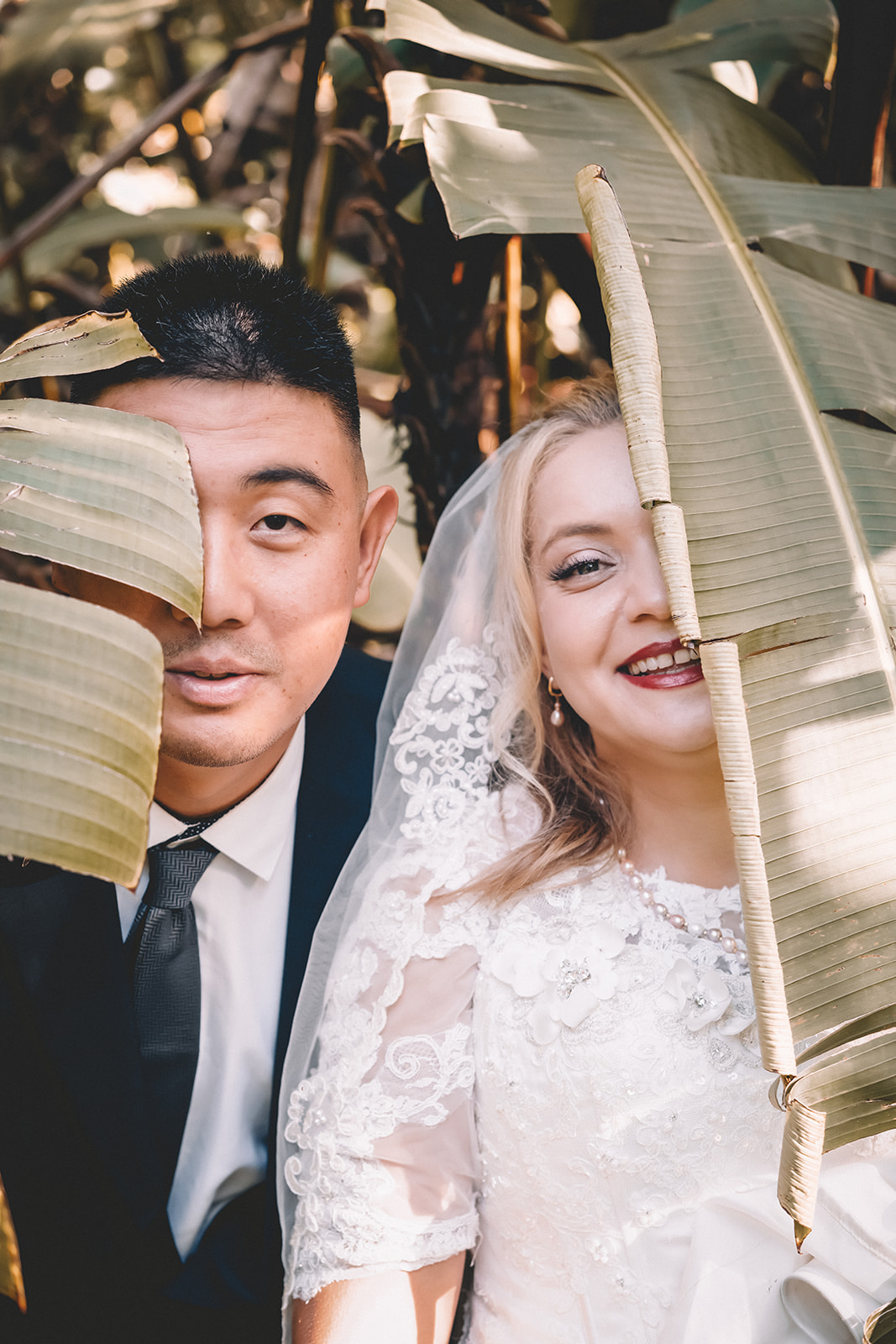 bride and groom covering face hiding hoomaluhia botanical garden