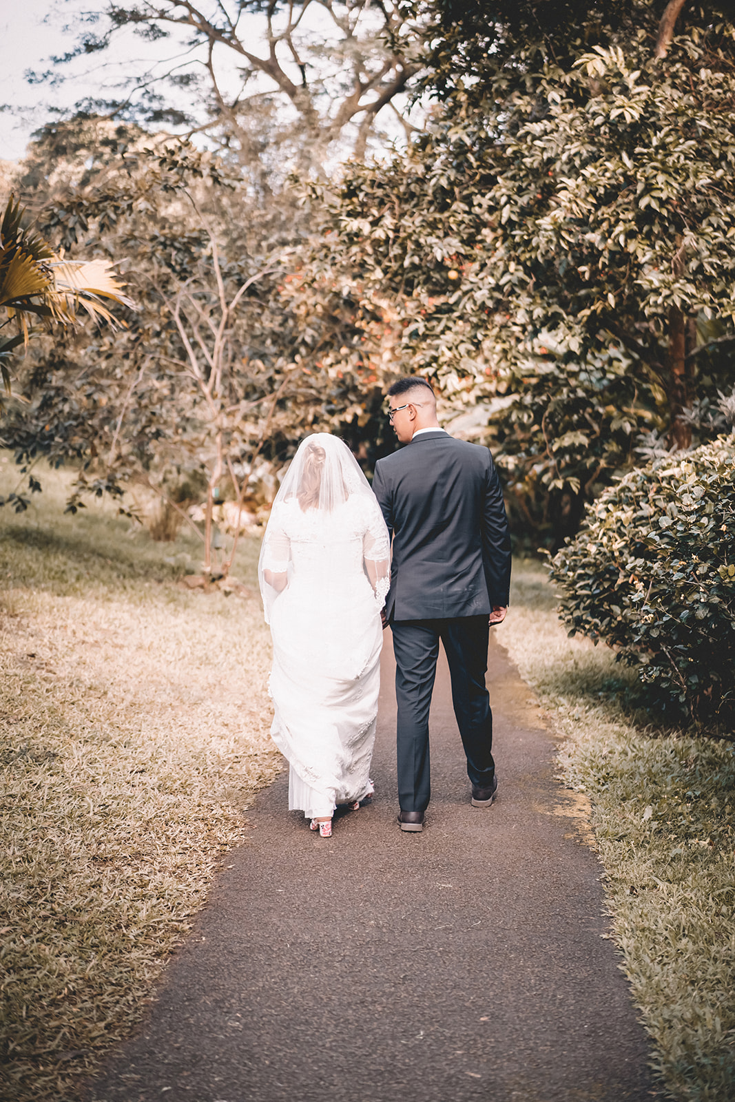 bride and groom walking away hoomaluhia botanical garden