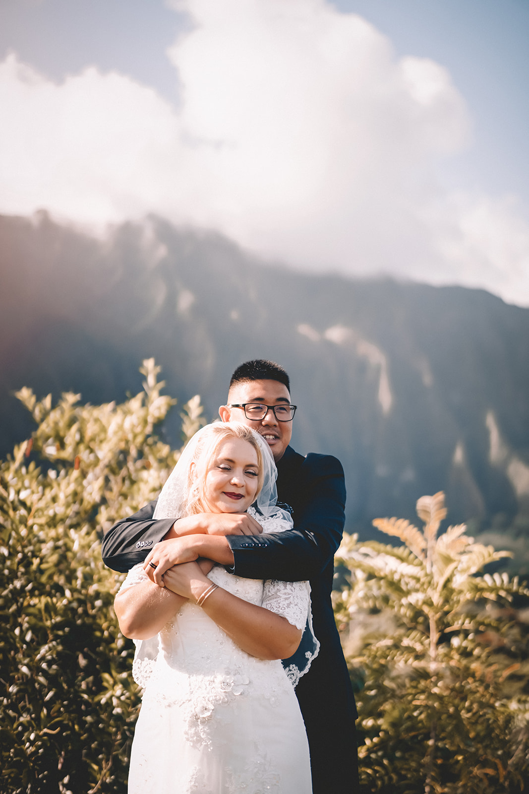 groom wrapped arms around bride hoomaluhia botanical garden