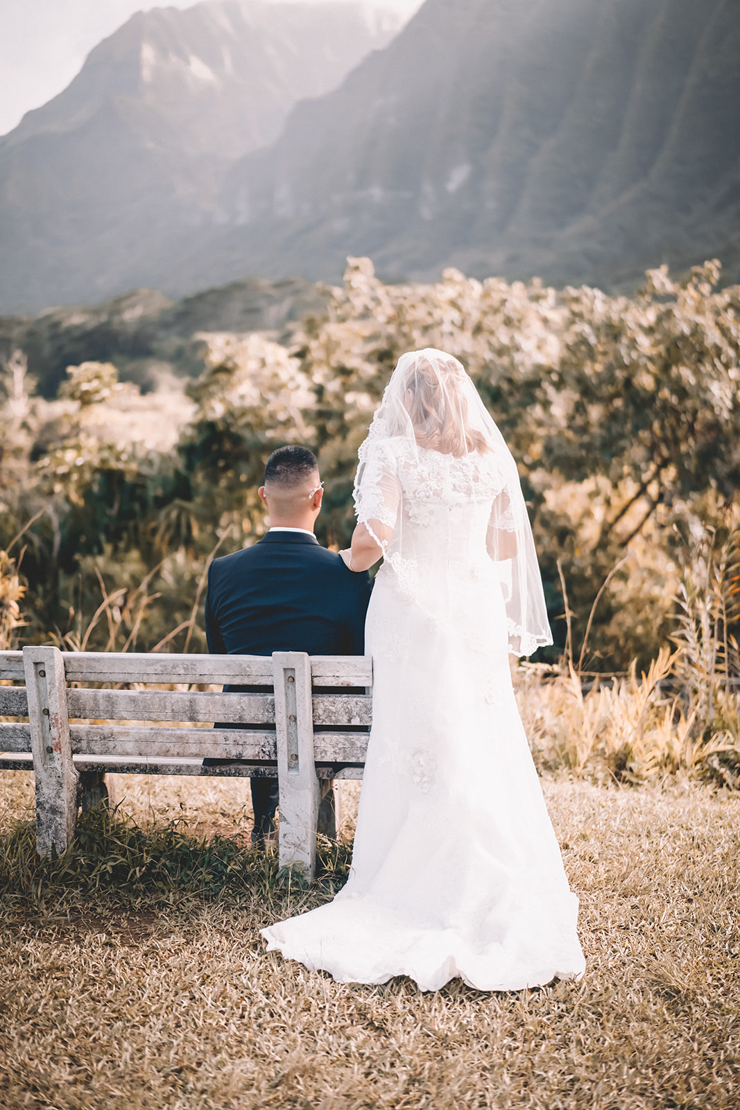 bride standing over groom Hoomaluhia botanical garden