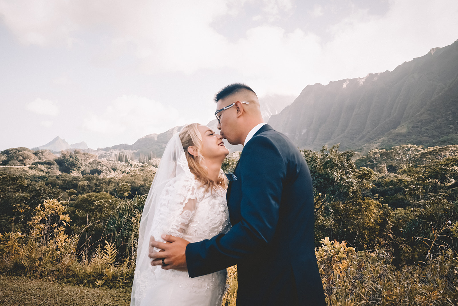 groom kissing bride to be's nose in hoomaluhia botanical garden