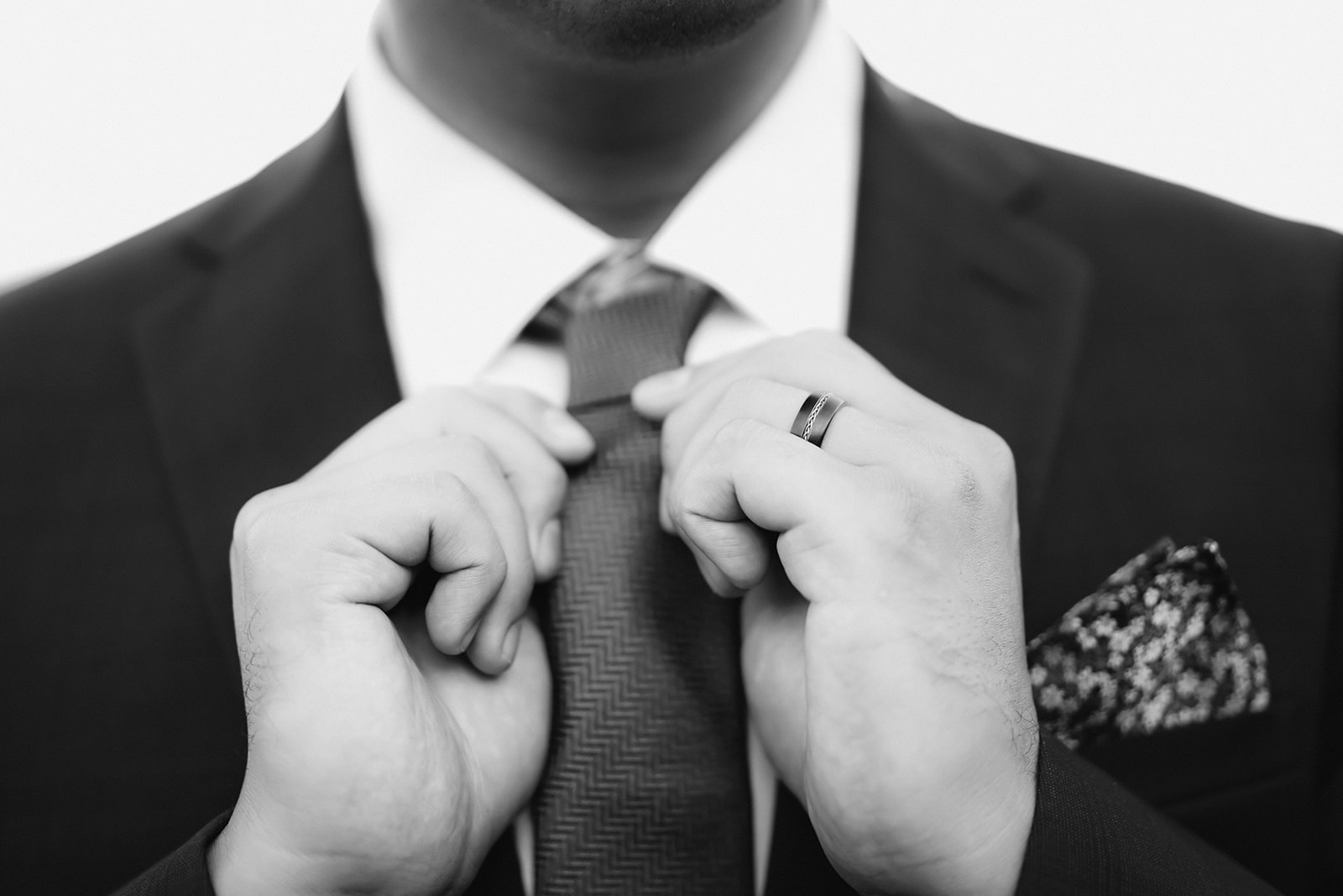 black and white photo man adjusting neck tie