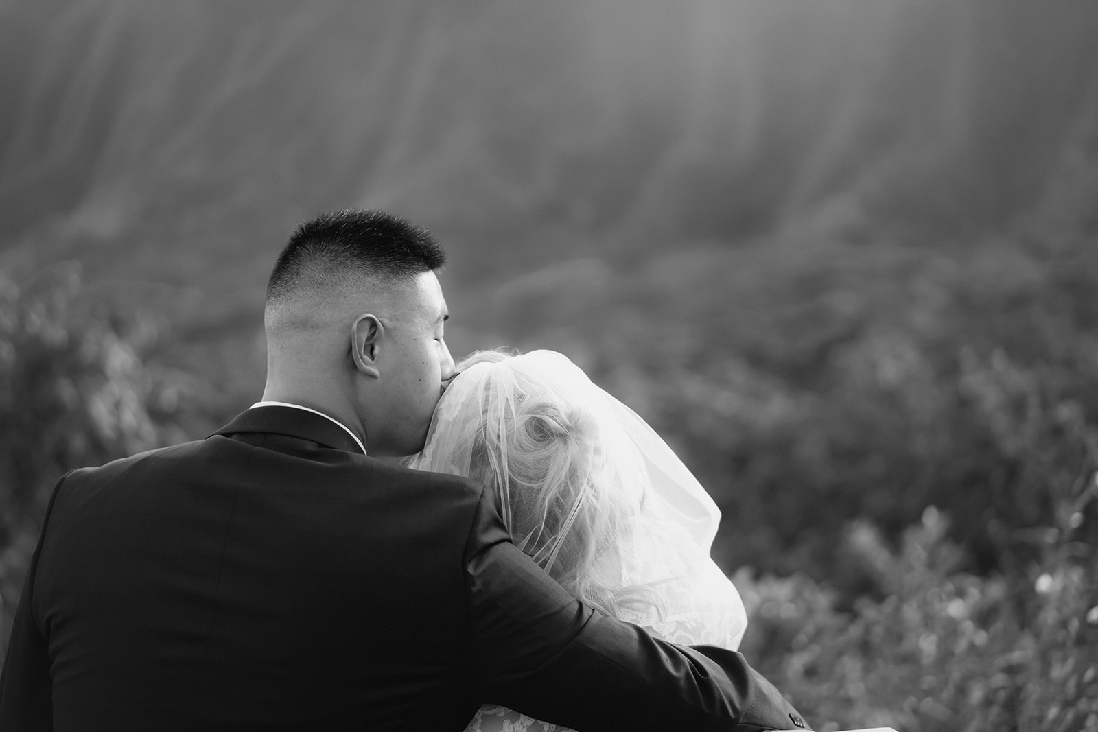 groom kissing bride's forehead hoomaluhia botanical garden
